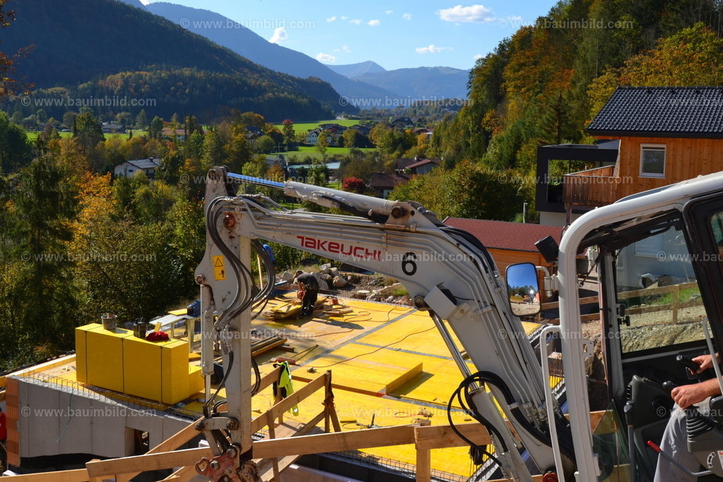 Keller mit Deckenschalung | Betonkeller in Berglandschaft, mit geschalter Geschoßdecke, im Vordergrund Bagger