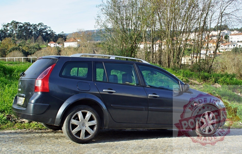 Renault Megane station wagon parked on rural road | Dark blue Renault Megane station wagon standing on a rural road near a village and trees - Realized with Pictrs.com