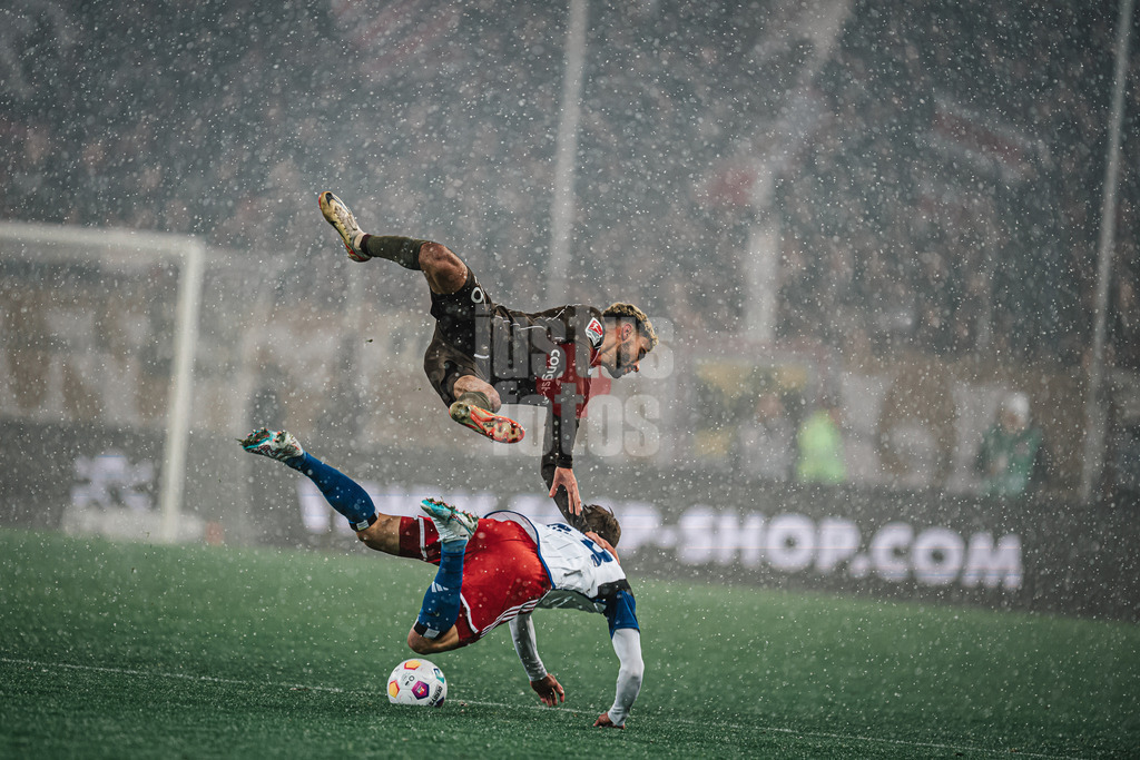 Fußball | Männer | Saison 2023/2024 | 2. Fußball-Bundesliga | 15. Spieltag | FC St. Pauli vs. Hamburger SV | 01.12.2023 | Harter Zweikampf zwischen Elias Saad (#26, oben, FC St. Pauli) und Miro Muheim (#28, unten, HSV) beide in der Luft im Schnee