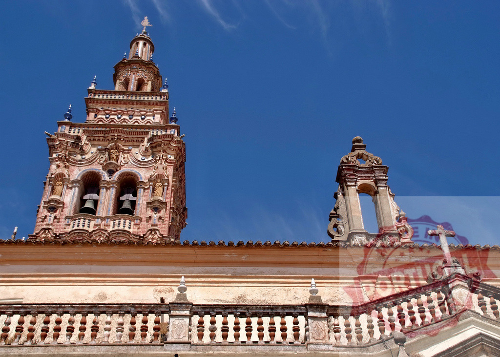 Historic Seville architecture and giralda style tower under blue sky. Extremdura - Spain | Ornate bell tower and rooftop architecture against a clear blue sky in Seville - Realized with Pictrs.com
