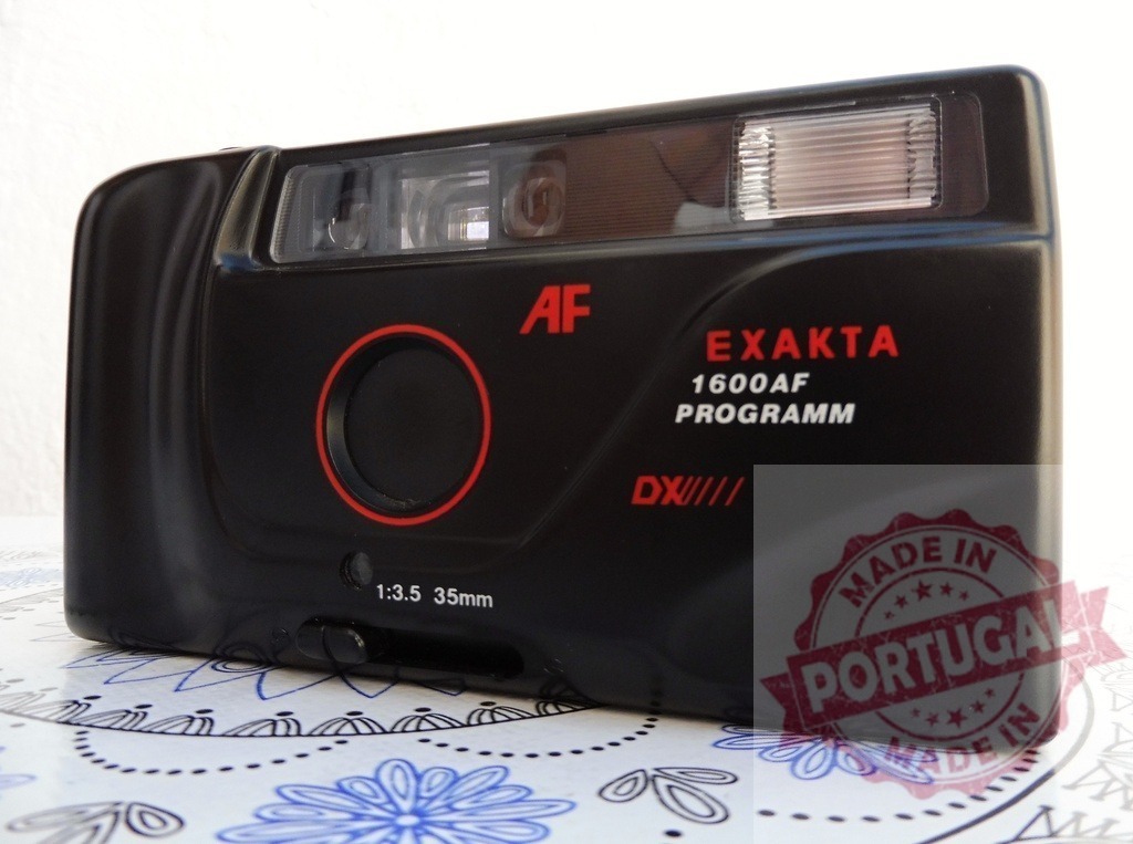 Exakta 1600AF point and shoot film camera | Exakta 1600AF vintage analog film camera resting on a decorative surface - Realized with Pictrs.com