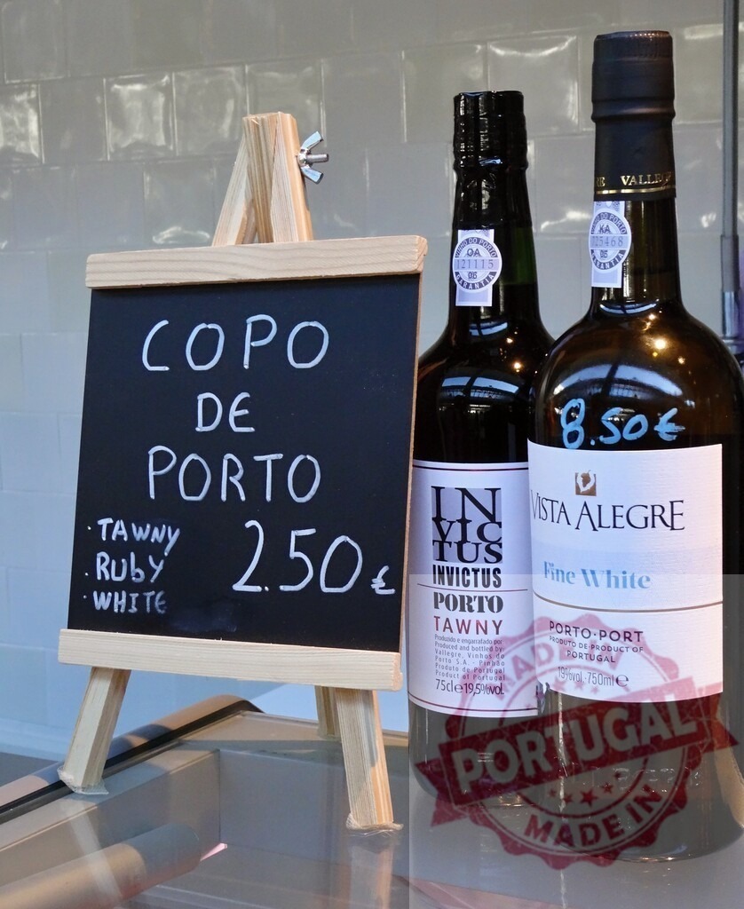 Porto wine tasting with Invictus and Vista Alegre bottles | Chalkboard displaying port wine options and prices alongside bottles of Tawny and White port - Realized with Pictrs.com