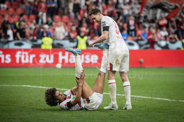 German Bundesliga, Bayer 04 Leverkusen vs. FC Augsburg, 18.04.2026 | LEVERKUSEN, GERMANY - APRIL 18, 2026 :  Han-Noah Massengo (FC Augsburg, 4) has a cramp, helped by Arthur Chaves (FC Augsburg, 34) during the German Bundesliga match on gameday 30 between Bayer 04 Leverkusen vs. FC Augsburg at BayArena on April 18, 2026 in Leverkusen, Germany. DFL REGULATIONS PROHIBIT ANY USE OF PHOTOGRAPHS AS IMAGE SEQUENCES AND/OR QUASI-VIDEO.