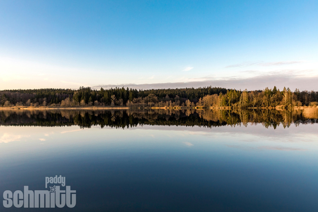 Argensee Wasserspiegelung bei Herbststimmung | Herbststimmung am Argensee im Allgäu. Die bunten Bäume und Wälder spiegeln sich im ruhigen Wasser und sorgen für ein stimmungsvolles homogenes Farbenspiel. - Realisiert mit Pictrs.com