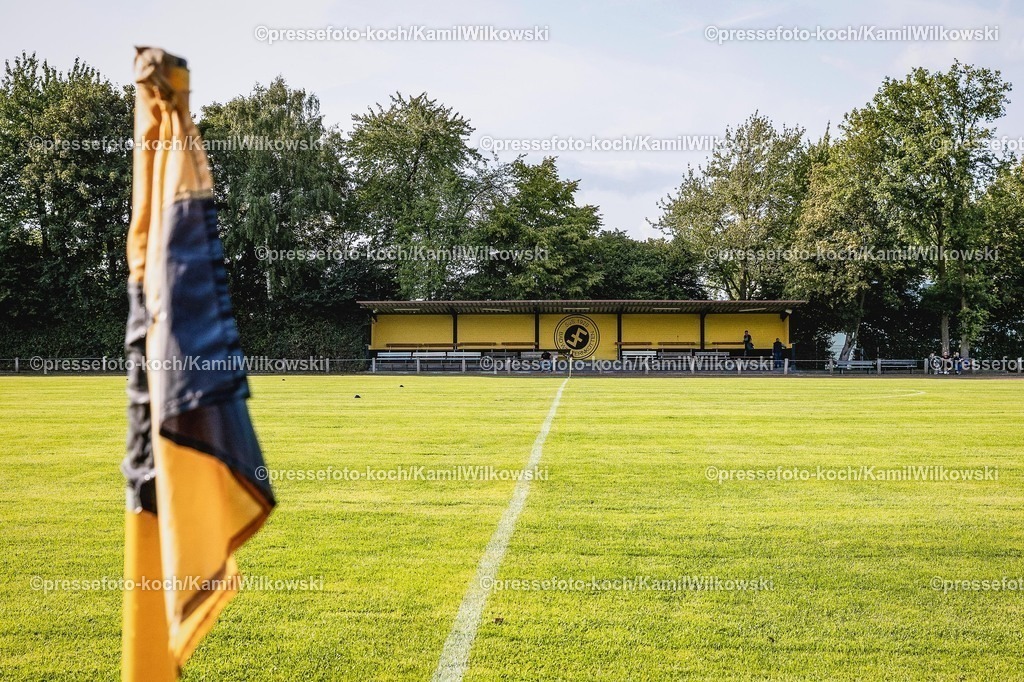 xkwi06082501002 | 06.08.2025, xkwix, Fußball, Krombacher Westfalenpokal, SuS Bad Westernkotten 1920 - SC Wiedenbrück, Stadion Am Zehnthof: Fahne am Spielfeld mit Tribüne