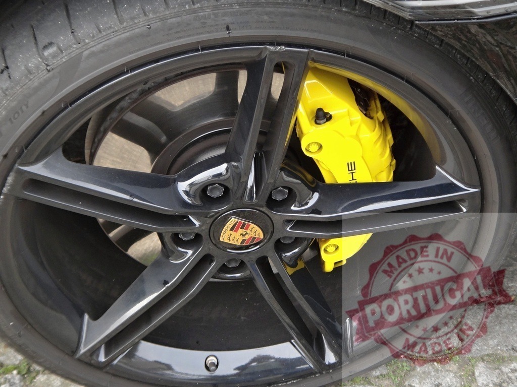 Porsche sports car wheel with yellow brake caliper | Porsche sports car wheel close-up featuring a black rim, tire, and yellow brake caliper - Realisiert mit Pictrs.com