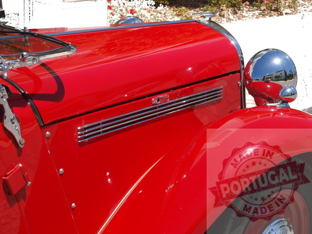 Shiny red vintage car parked outdoors showing hood and headlight | Close-up of a polished red vintage car highlighting its hood, chrome grill, and headlight - Realisiert mit Pictrs.com