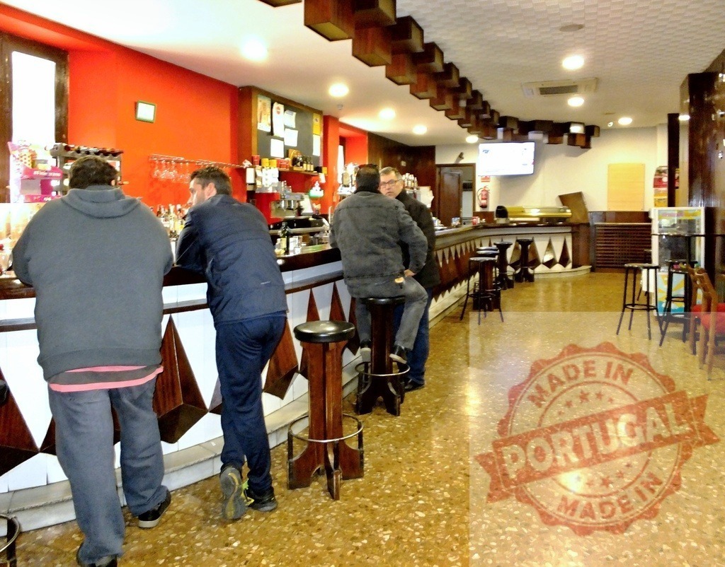 Customers socializing and drinking at bar counter | People drinking and talking at a bar counter with stools in a casual tavern setting - Realisiert mit Pictrs.com