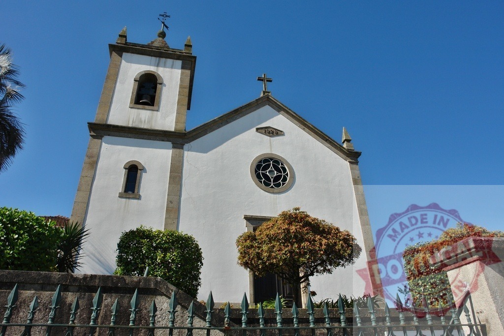 Portuguese church facade with bell tower and blue sky. Region Norte - Portugal | White church building with a bell tower and cross, standing against a clear blue sky - Realisiert mit Pictrs.com