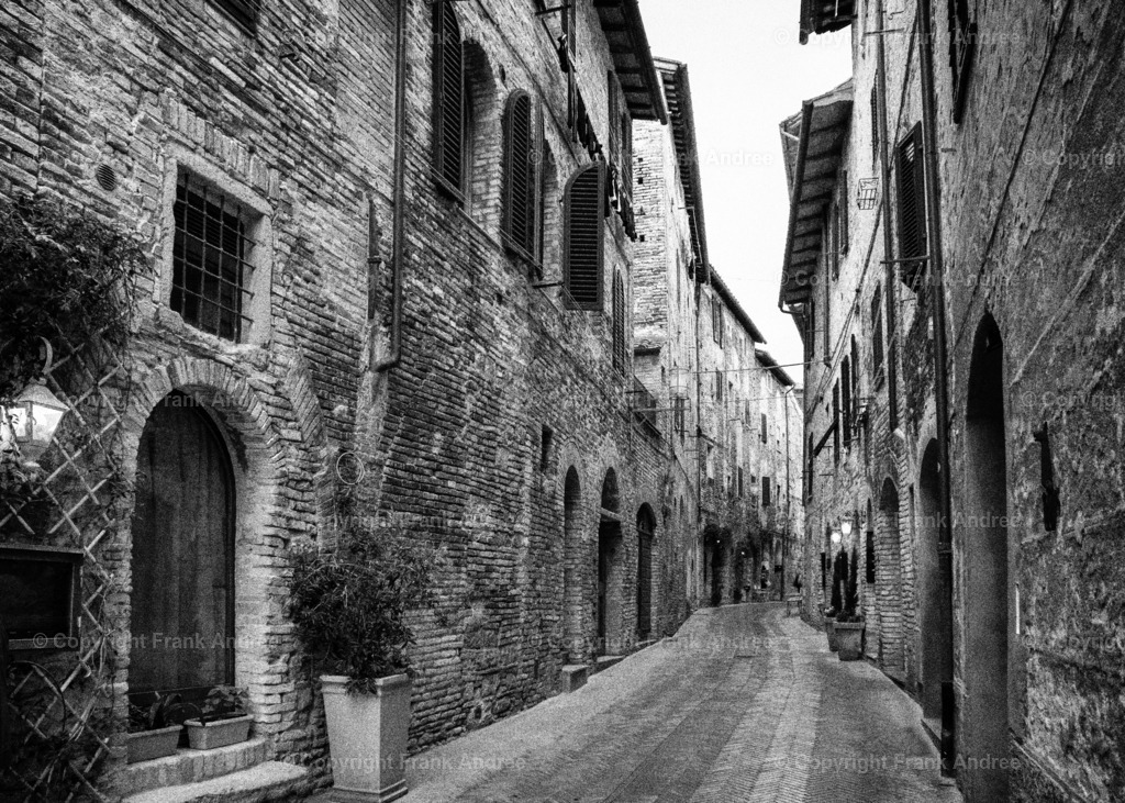 Auf den Straßen der Toskana | San Gimignano mit seiner mittelalterlichen Altstadt ist immer wie eine Reise in die Vergangenheit
Schwarz weiß Fotografie einer mittelalterlichen Straße in der traumhaft schönen Altstadt von San Gimignano im Herzen der Toskana. - Realisiert mit Pictrs.com