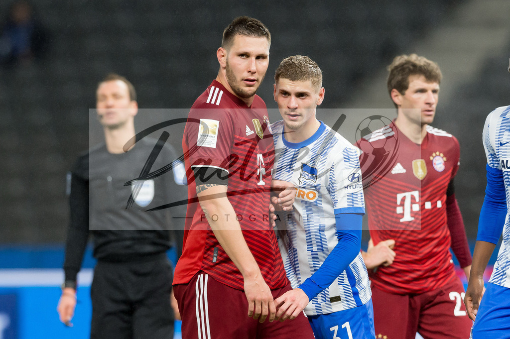 BSCFCB20220123_286 | Fussball, Herren: Niklas Suele (FC Bayern Muenchen) und Marton Dardai (Hertha BSC) schauen bei dem Spiel der 1. Bundesliga zwischen Hertha BSC und FC Bayern Muenchen im Olypiastadion am 23.01.2022 in Berlin, Deutschland.DFB / DFL REGULATIONS PROHIBIT ANY USE OF PHOTOGRAPHS AS IMAGE SEQUENCES AND/OR QUASI-VIDEO. - Realisiert mit Pictrs.com