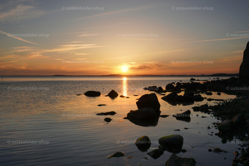 Sonnenuntergang am Zickerschen Höft | Das Bild zeigt die Boddenküste am Zickerschen Höft. Im Licht der untergehenden Sonne scheinen die vielen Steine wie in einem märchenhaften Scherenschnitt auf dem Wasser zu laufen.  