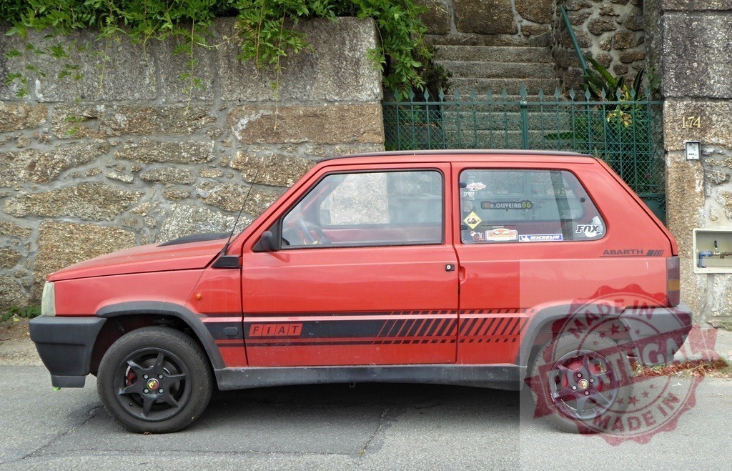 Red Fiat Panda Abarth classic car parked outdoors | Red Fiat Panda Abarth vintage car parking on a street next to a stone wall - Realized with Pictrs.com