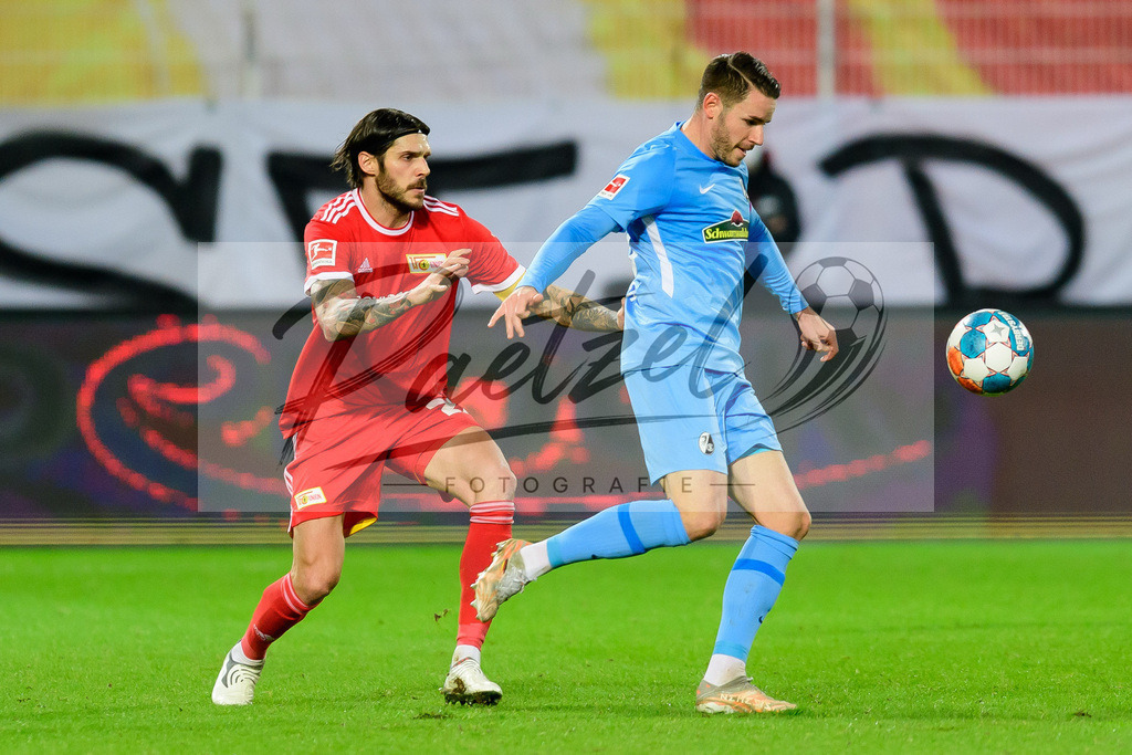 FCUFRE20211215_032 | Fussball, Herren: Christopher Trimmel (1. FC Union Berlin) und Vincenzo Grifo (SC Freiburg) im Zweikampf bei dem Spiel der 1. Bundesliga zwischen 1. FC Union Berlin und SC Freiburg im Stadion An der Alten Foersterei am 15.12.2021 in Berlin, Deutschland.DFB / DFL REGULATIONS PROHIBIT ANY USE OF PHOTOGRAPHS AS IMAGE SEQUENCES AND/OR QUASI-VIDEO. - Realisiert mit Pictrs.com