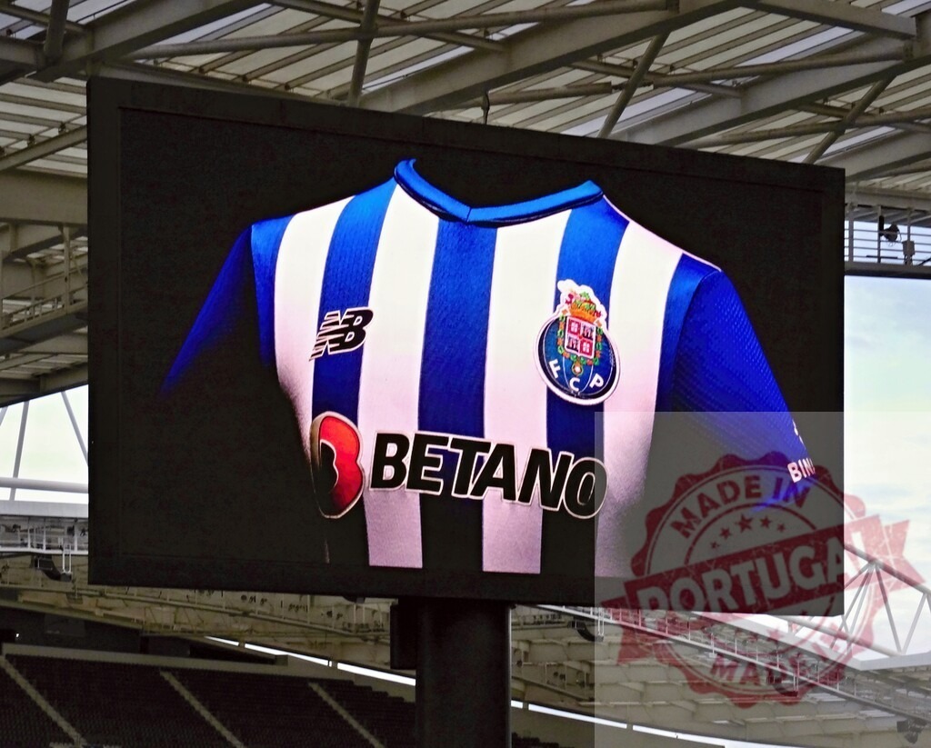 FC Porto football jersey advertising on stadium screen | FC Porto jersey with Betano and New Balance logos displayed on a large stadium video screen - Realisiert mit Pictrs.com