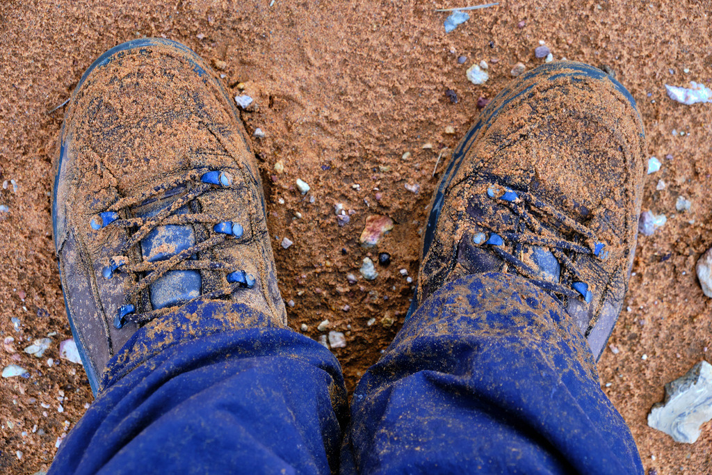 verschmutze Wanderschuhe im Sand | Marokko - November 17, 2024: verschmutze Wanderschuhe im Sand, nach einer Wanderung. - Realisiert mit Pictrs.com