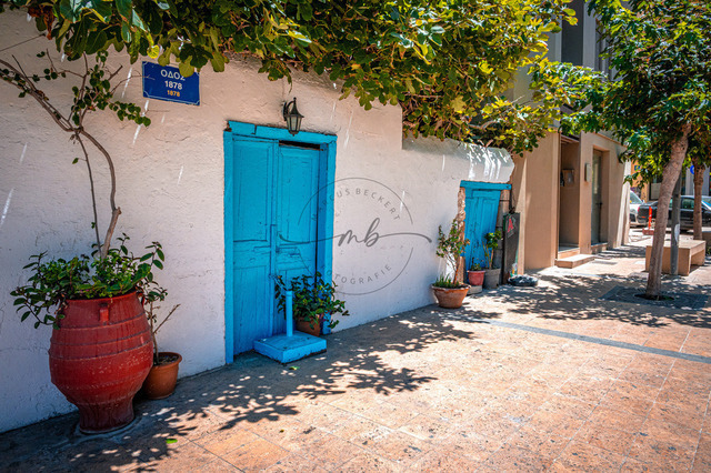 2026-07-20_11-45-38_840 | Charmante Gasse mit blauen Türen und Pflanzen an einem sonnigen Tag, Heraklion, Kreta, Griechenland - Realisiert mit Pictrs.com