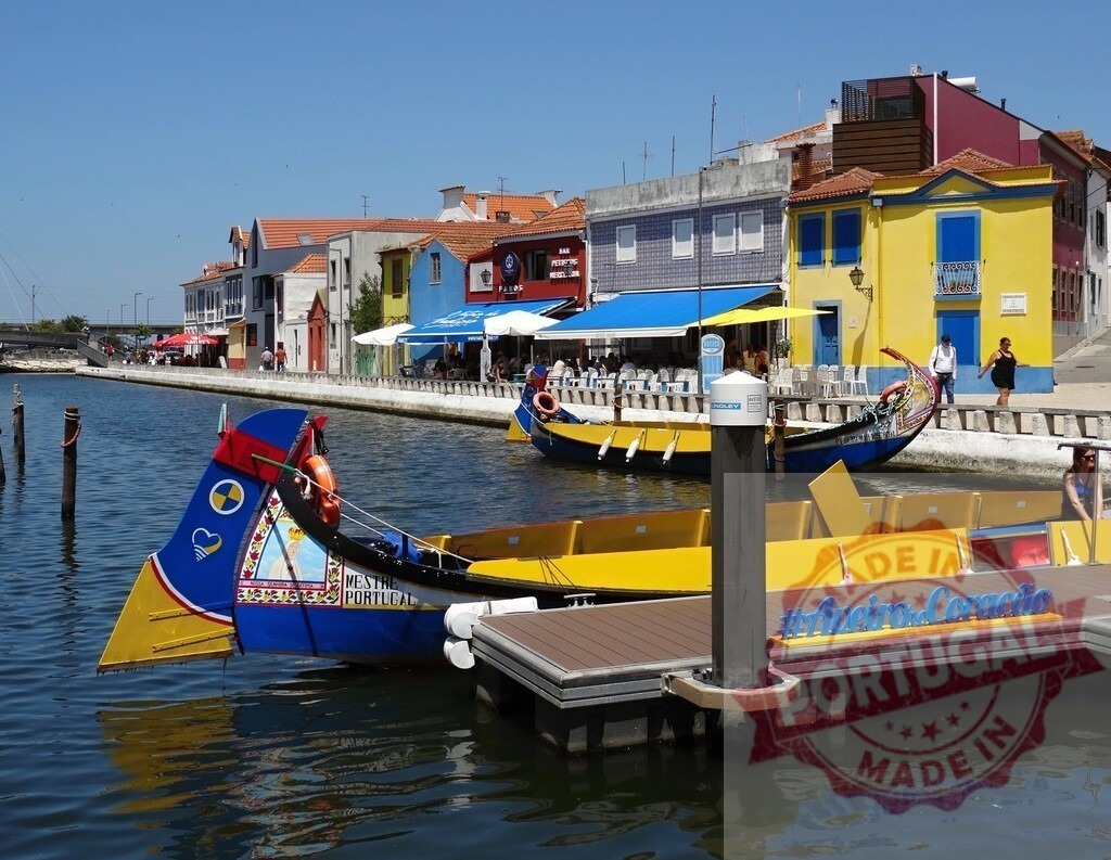Aveiro canals with colorful moliceiro boats and charming houses. Aveiro - Portugal | Aveiro, Portugal featuring traditional moliceiro boats navigating a canal past vibrant buildings - Realisiert mit Pictrs.com