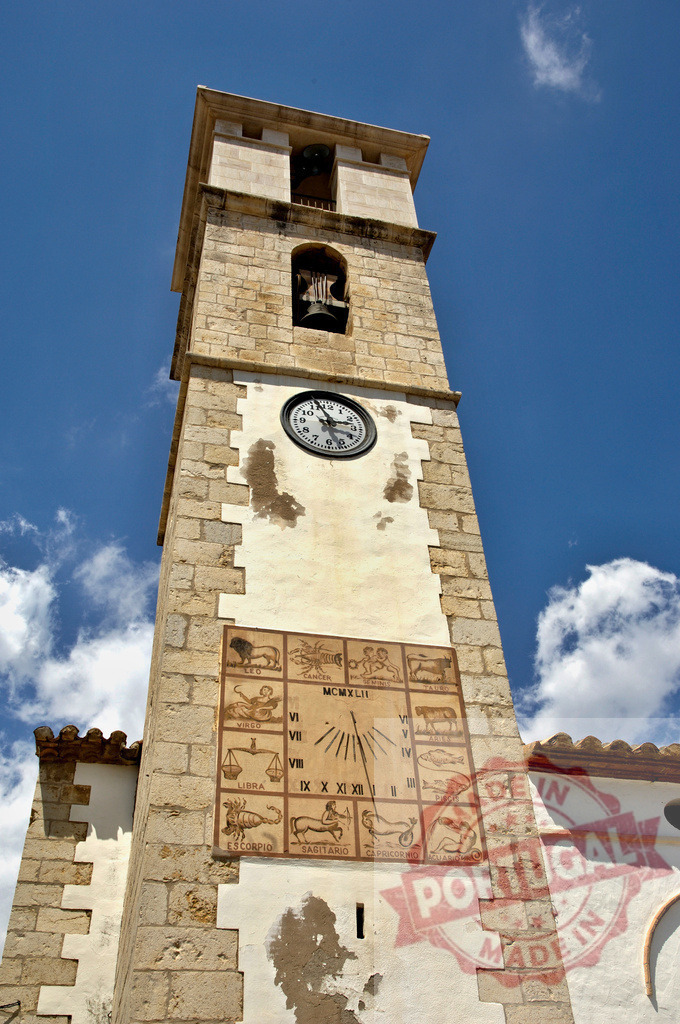 Historic church clock tower with sundial and zodiac signs | Stone bell tower displaying sun clock, astrology symbols, and classic timepiece against blue sky - Realized with Pictrs.com
