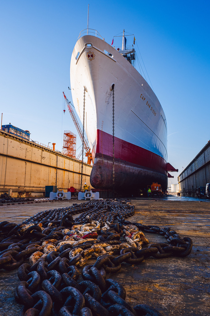 Der Weiße Schwan im Trockendock | Das größte fahrtüchtige Museums-Frachtschiff der Welt während eines Werftaufenthalts im Trockendock in Bremerhaven.Die Aufnahme zeigt den historischen Stückgutfrachter zur Klassenerneuerung im Dock. Die am Dockboden ausgelegten Ankerketten verdeutlichen die Dimensionen des Schiffes und den technischen Aufwand für den Erhalt des maritimen Denkmals. - Realisiert mit Pictrs.com