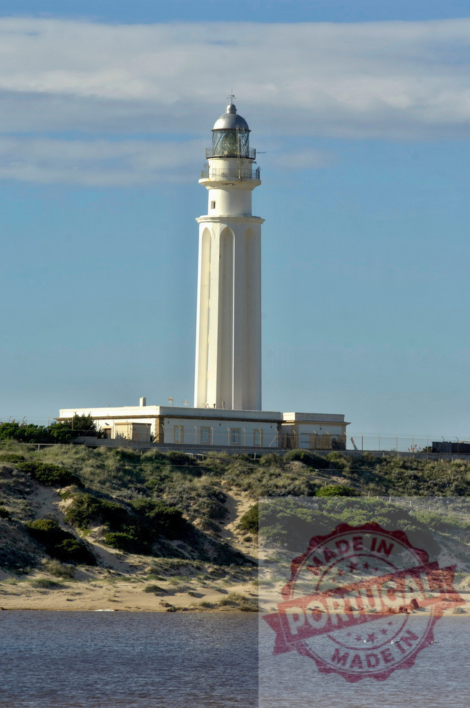 Trafalgar lighthouse standing on coastal dunes Spain. Espana - Cadiz | Trafalgar lighthouse providing guidance for navigation on the coast of Cadiz, Spain - Realized with Pictrs.com