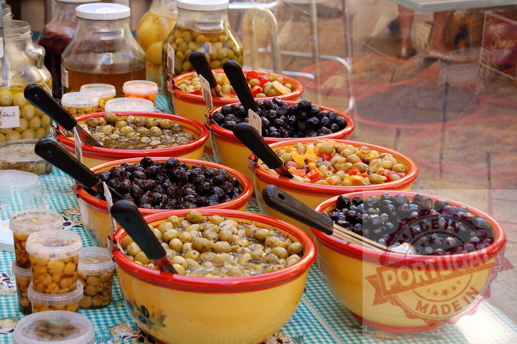 Various olives and antipasto in market bowls | Different olive varieties and pickled vegetables filling colorful bowls at a street market stall - Realisiert mit Pictrs.com