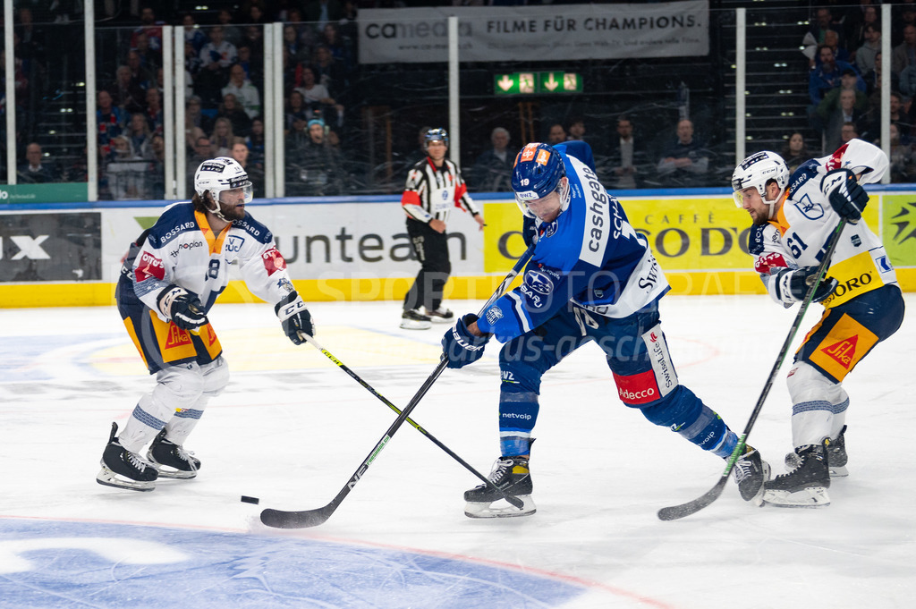 Swiss National League Final Game 2: ZSC Lions - EV Zug | 20.04.2022, Zürich, Hallenstadion, Swiss National League Final Game 2: ZSC Lions - EV Zug, #19 Reto Schäppi (ZSC) nimmt den Abschluss zwischen #18 Dominik Schlumpf (Zug) und #61 Sven Leuenberger (Zug). - Realisiert mit Pictrs.com