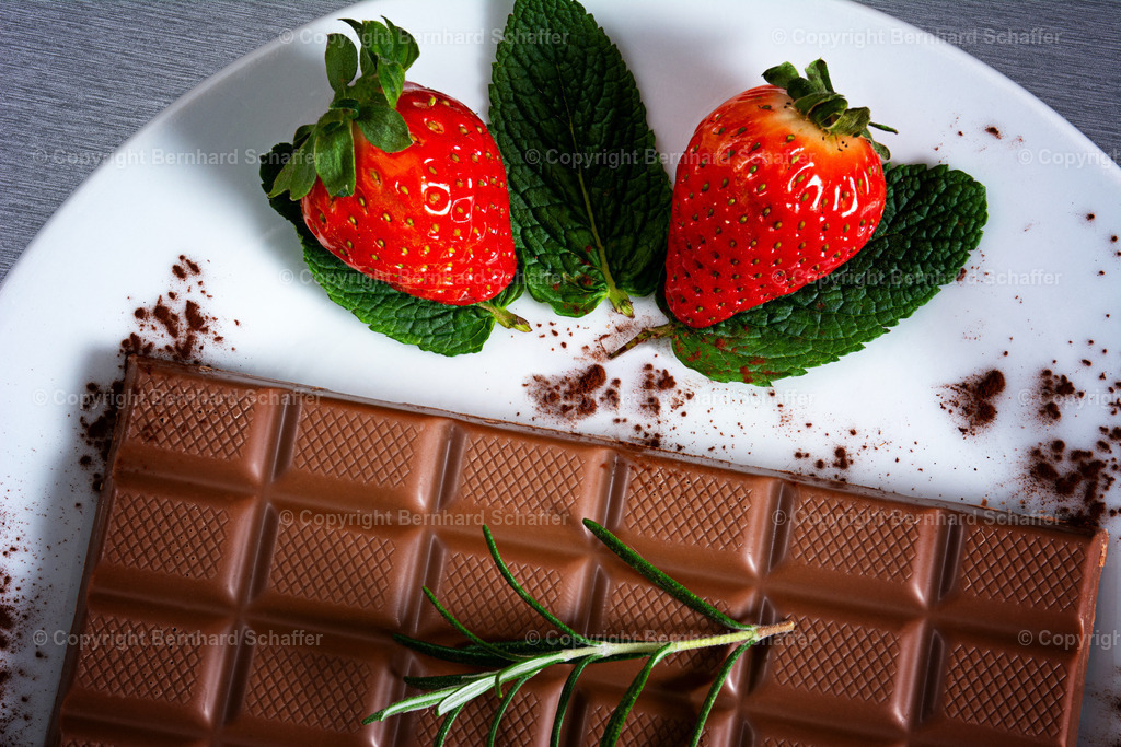 Erdbeer und Schokolade | Eine Tafel Schokolade und Erdbeeren liegen auf einem Teller. - Realisiert mit Pictrs.com