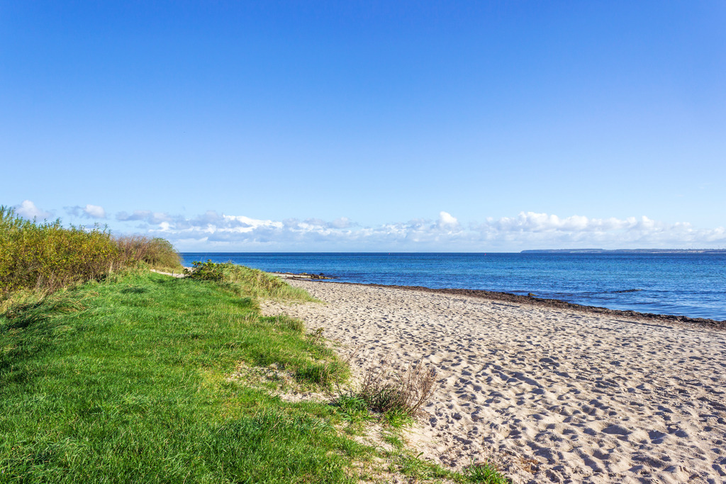 Wandbild: Strand in Karlsminde | Dieses Wandbild im Querformat zeigt den Strand in Karlsminde. Der blaue Himmel ist fast wolkenlos.  - Realisiert mit Pictrs.com