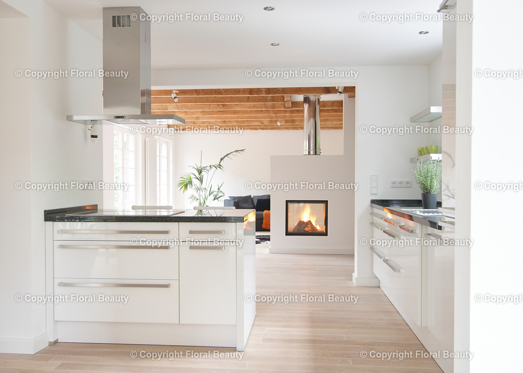 Umbau eines Rotklinkerhauses | Kochinsel in Hochglanzküche mit Blick auf Kamin in Wohnzimmer - Realisiert mit Pictrs.com