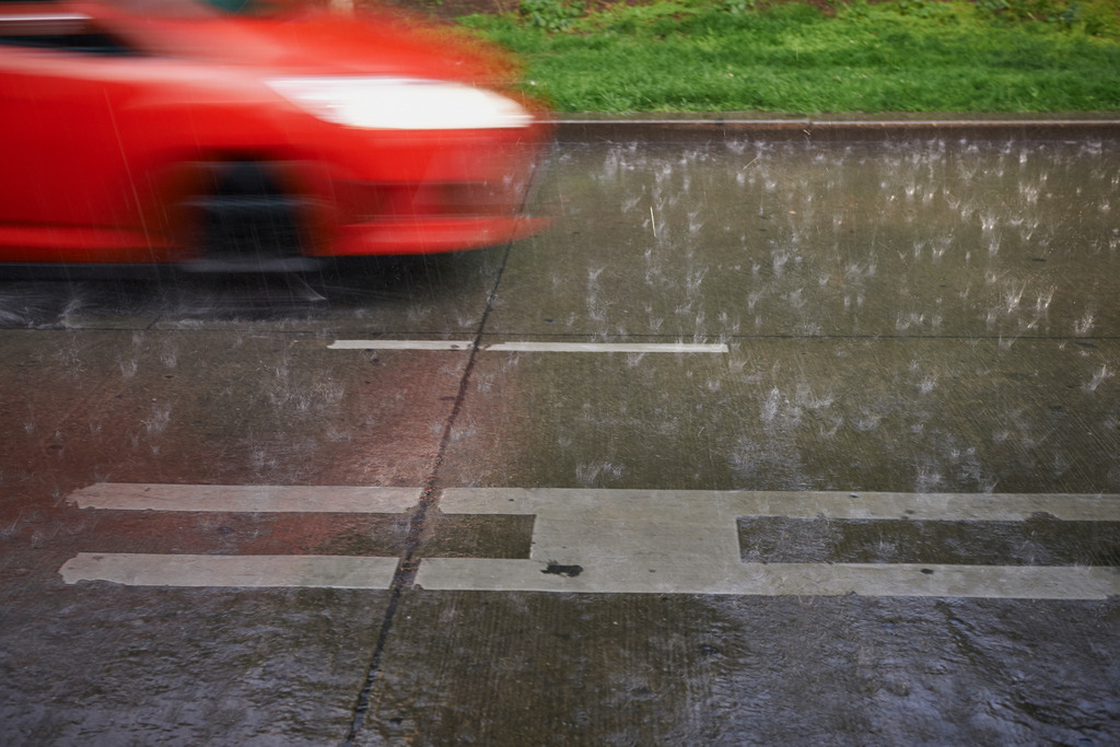 Gewitterregen an Bushaltestelle | Wien, Austria - May 02, 2014: Gewitterregen an an einer Bushaltestelle mit vorbeifahrendem roten Auto. - Realisiert mit Pictrs.com