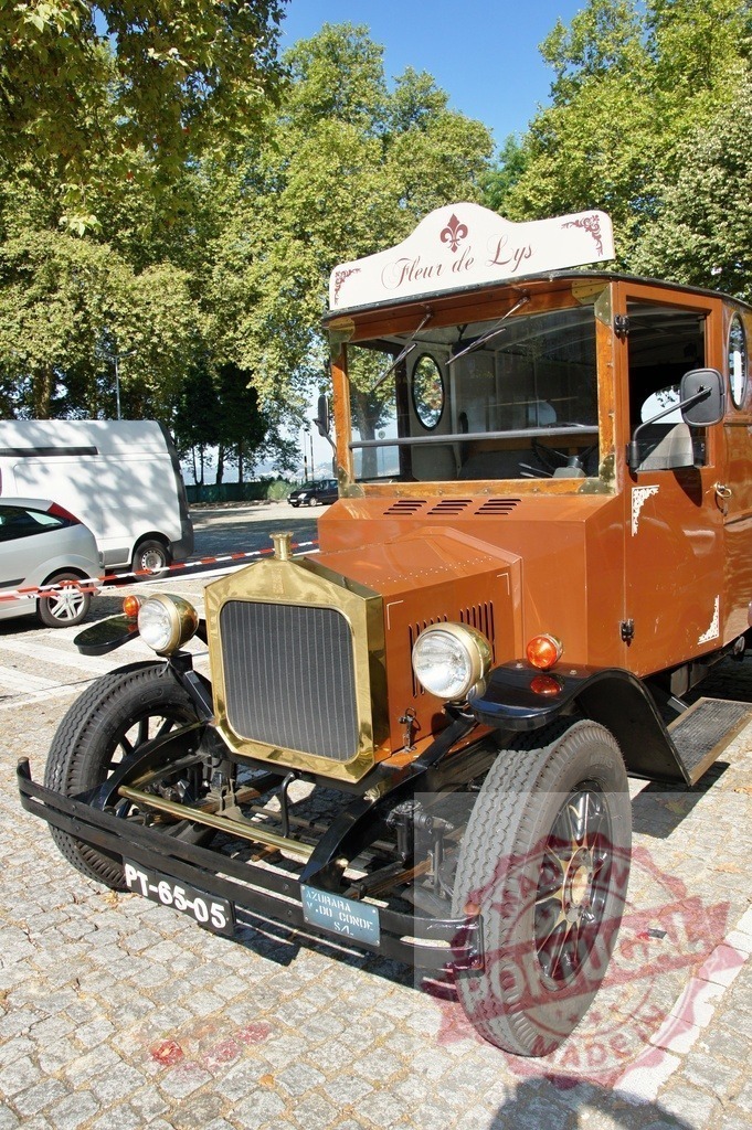 Restored vintage truck Fleur de Lys parked on cobblestone street | Antique brown truck parked in a cobblestone street, showing its restored front and the name Fleur de Lys - Realisiert mit Pictrs.com