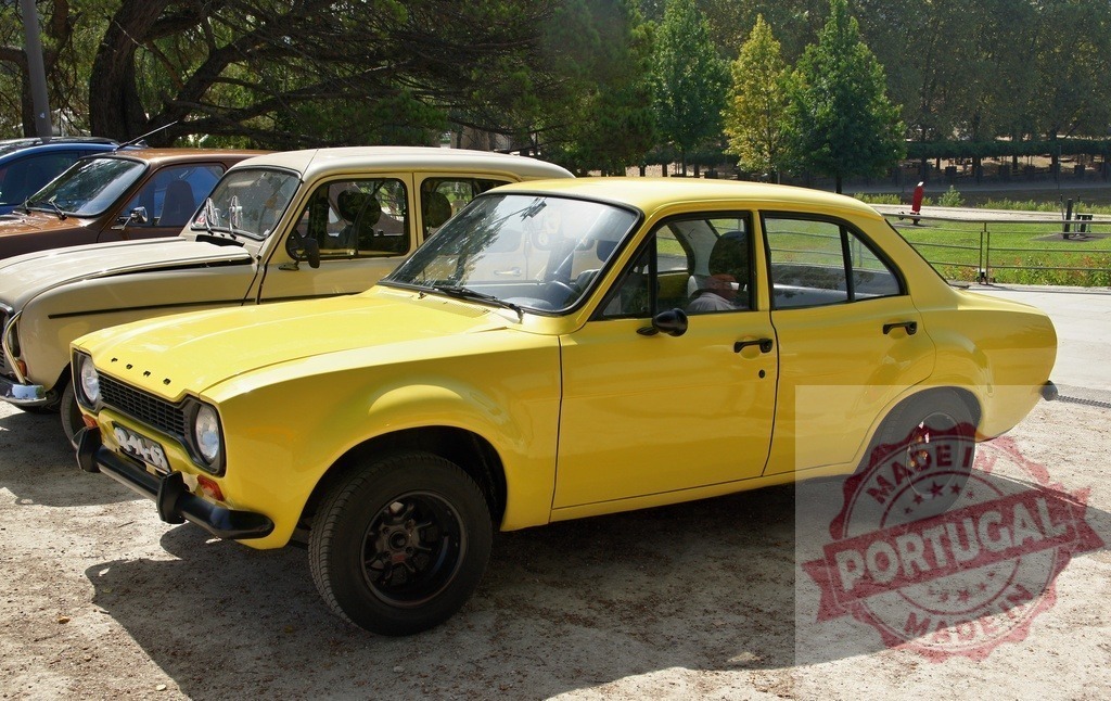 Yellow Ford Escort parked at a classic car show | Bright yellow 1970s Ford Escort sedan displaying a vintage design outdoors - Realized with Pictrs.com