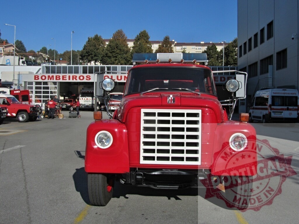 Vintage red fire truck parked outside Bombeiros station | Red firefighter truck waiting for emergency at the fire station entrance - Realized with Pictrs.com