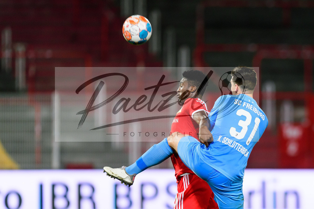 FCUFRE20211215_033 | Fussball, Herren: Taiwo Awoniyi (1. FC Union Berlin) und Keven Schlotterbeck (SC Freiburg) im Zweikampf bei dem Spiel der 1. Bundesliga zwischen 1. FC Union Berlin und SC Freiburg im Stadion An der Alten Foersterei am 15.12.2021 in Berlin, Deutschland.DFB / DFL REGULATIONS PROHIBIT ANY USE OF PHOTOGRAPHS AS IMAGE SEQUENCES AND/OR QUASI-VIDEO. - Realisiert mit Pictrs.com