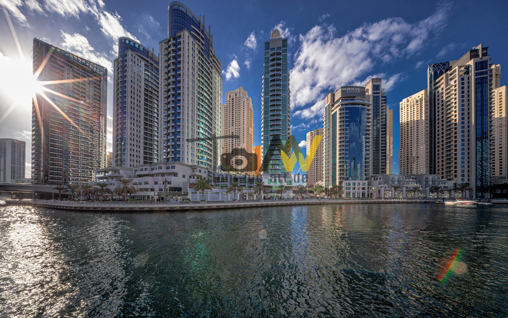 Futuristische Architektur in der Dubai Marina in Dubai--VI | Die Abbildung zeigt die Dubai Marina, ein bekanntes Viertel in Dubai, das für seine beeindruckende Skyline und den künstlichen Yachthafen bekannt ist. Das Viertel liegt an einer 3 Kilometer langen künstlichen Wasserstraße und verfügt über eine belebte, 7 Kilometer lange Promenade, den "Marina Walk". Es ist bekannt für seine hohe Dichte an Wolkenkratzern und luxuriösen Wohngebäuden, von denen einige zu den höchsten der Welt gehören. Die Gegend bietet eine Mischung aus urbanem Lebensstil und Strandnähe, mit zahlreichen Restaurants, Bars und Geschäften entlang der Promenade. Die Dubai Marina gilt als eines der stilvollsten und beliebtesten Ziele für Touristen und Einheimische gleichermaßen.  - Realisiert mit Pictrs.com