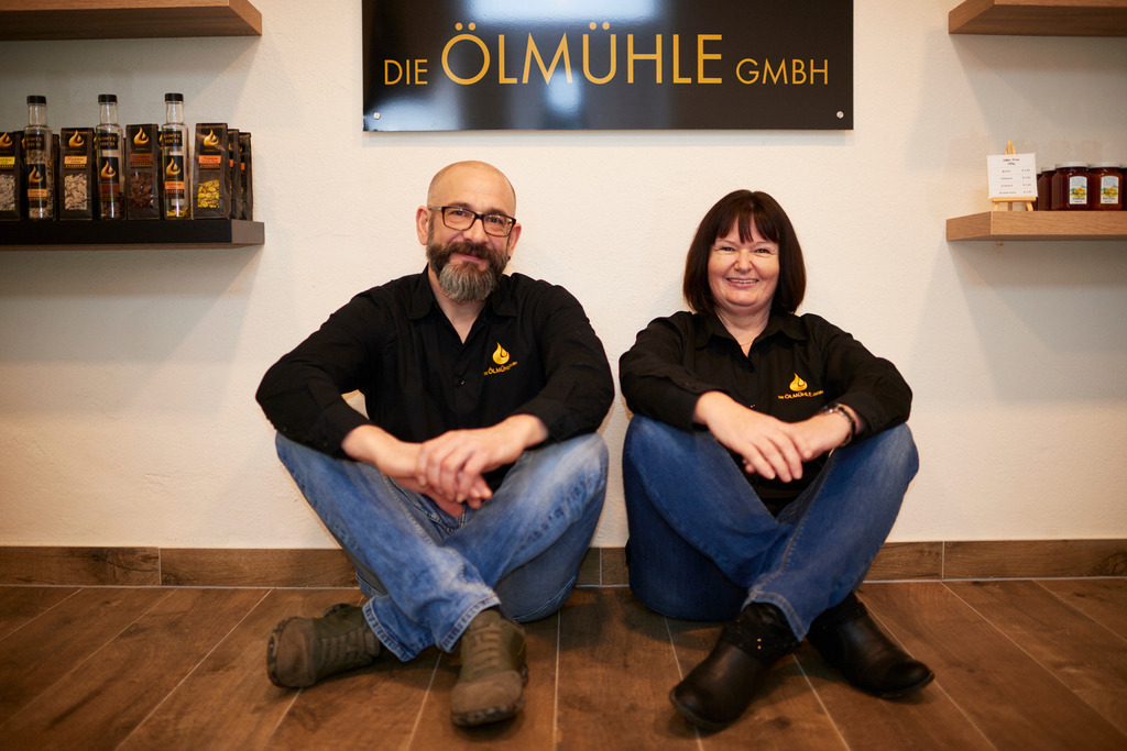Die Ölmühle | Markt Allhau, Austria - February 09, 2018: Die Ölmühle; Herr Karl Grossschedl und Geschäftsführerin Helga Gradwohl im Verkaufsraum unter dem Logo sitzend. - Realisiert mit Pictrs.com
