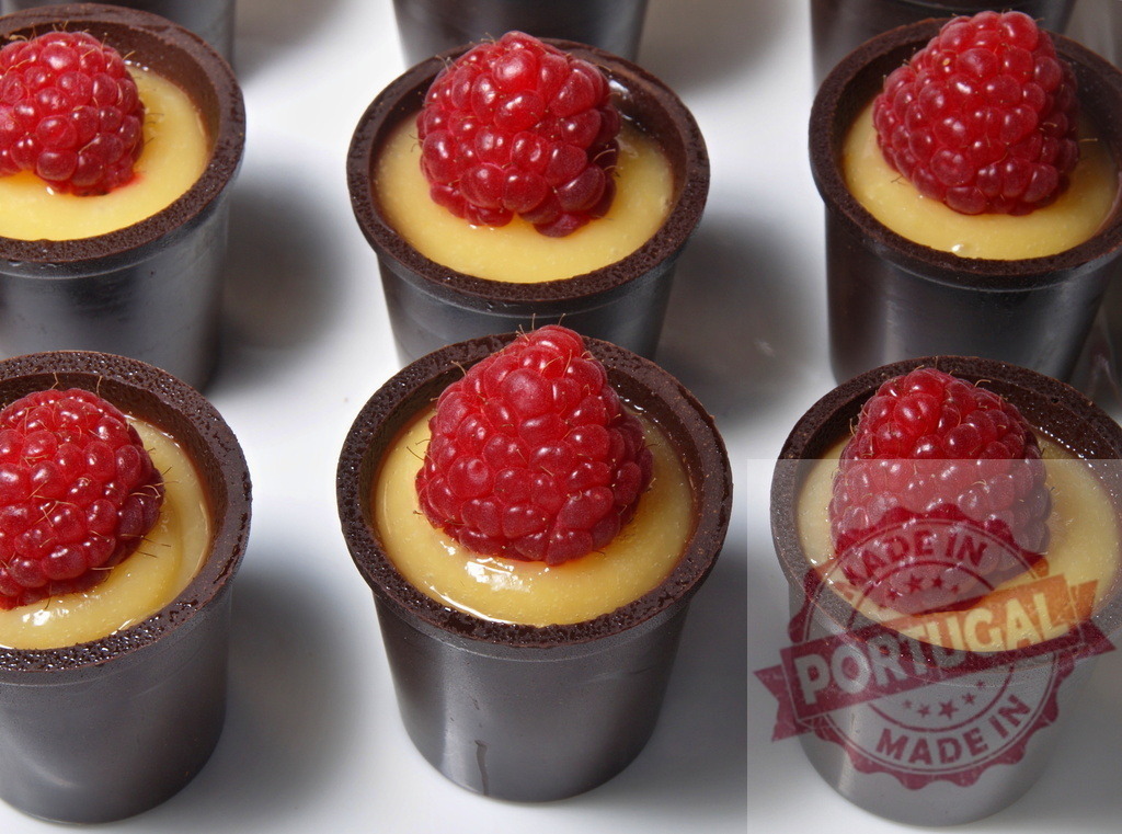 Chocolate cups with berry mousse dessert | Chocolate cups filled with golden mousse and fresh raspberries, arranged for an elegant presentation - Realisiert mit Pictrs.com