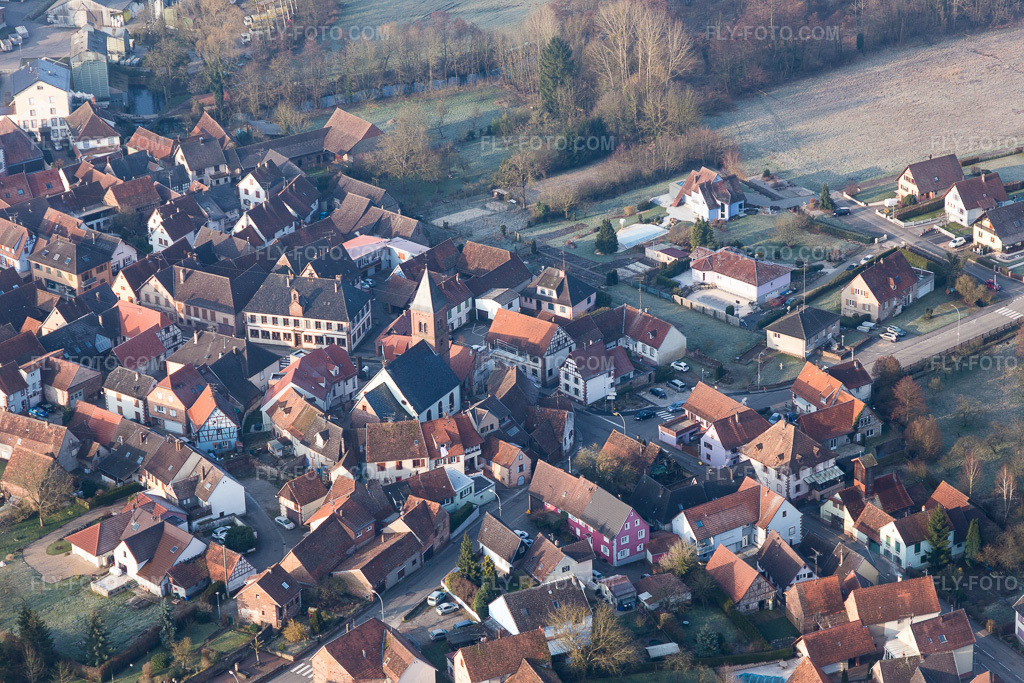 Aerial view: Lutheran-Protestant fortified church in the village center, surrounded by a ring of houses in Dossenheim-sur-Zinsel in the state Bas-Rhin, France.Photo: IMG_105322.jpg taken on 03/25/2018 by Werner Riehm/FLY-FOTO.comResolution of the original: 5472 x 3648 px