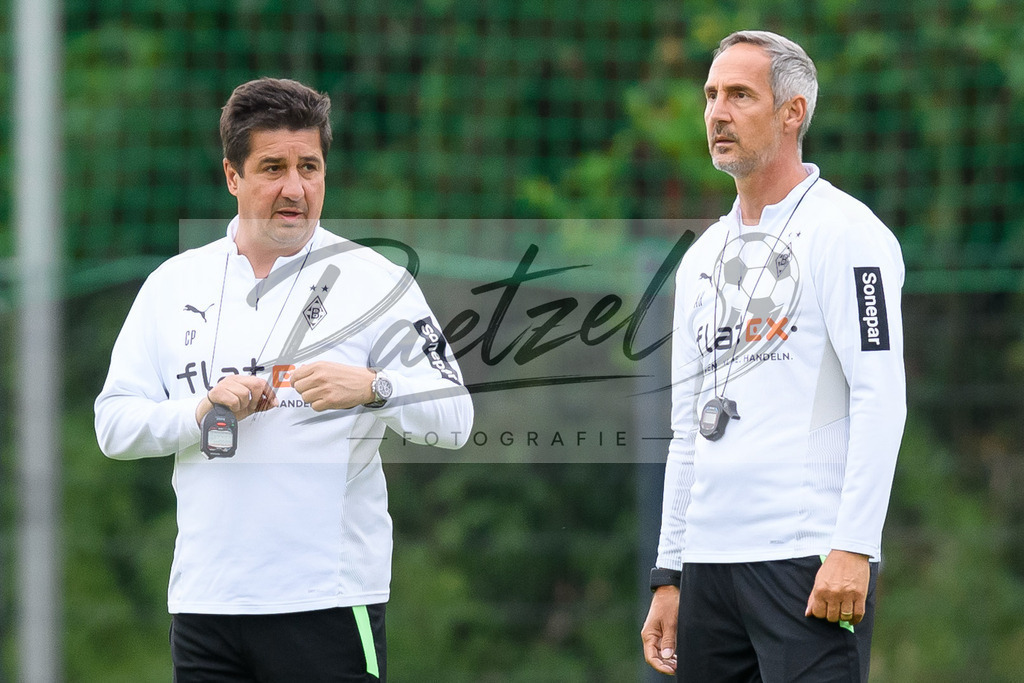 TRABMG20210719_015 | Fussball, Herren: Co-Trainer Christian Peintinger (Borussia Moenchengladbach) und Trainer Adi Huetter (Borussia Moenchengladbach) schauen beim Training von Borussia Moenchengladbach waehrend des Trainingslagers auf dem Trainingsplatz am Hotel Klosterpforte am 19.07.2021 in Harsewinkel, Deutschland. - Realisiert mit Pictrs.com
