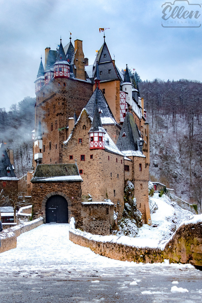 Winter’s Embrace at Eltz Castle | Snow blankets the ancient walls of Burg Eltz, wrapping the medieval fortress in quiet grace. Mist rises from the valley, and time seems to hold its breath in this fairytale corner of Germany. - Realisiert mit Pictrs.com