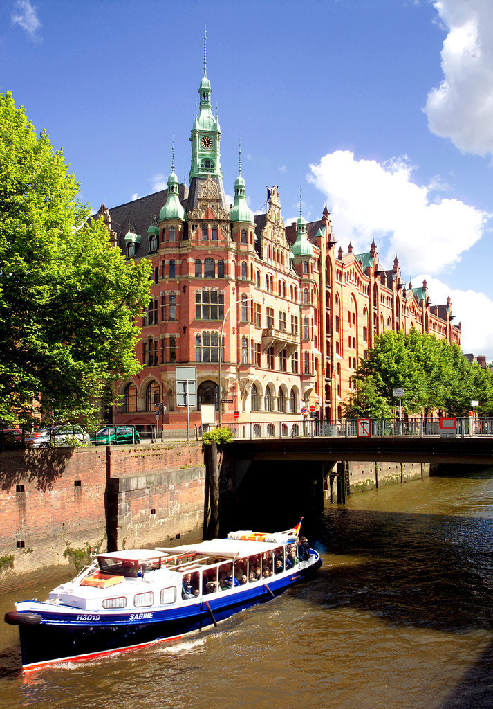 Rathaus der Speicherstadt mit Barkasse | Das Rathaus der Hamburger Speicherstadt, die Zentrale der HHLA, mit einer typischen Hafenbarkasse mit Touristen. - Realisiert mit Pictrs.com