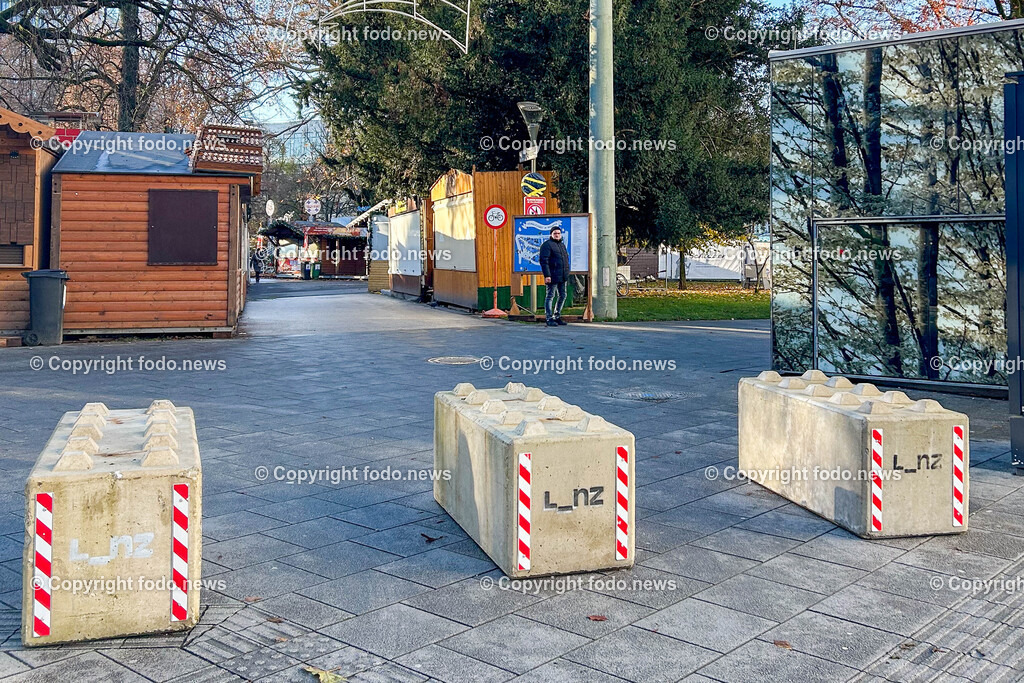 Linz_ Weihnachtsmarkt_ Terrorschutz_ 18.11.2025-8 | 18.11.2025, LINZ, AUT, Weihnachtsmarkt, im Bild Themenbild, Betonbarrieren, Betonblock, Terrorschutz, Volksgarten, Stadt, L_nz, Sicherheit, Fußgaengerzone, Weihnachtsmarkt, Huetten, Winter, Bauume ohne Laub, Absperrung, Verkehrsschutz, oeffentlicher Platz, Menschen, urban, Feature, Symbolbild