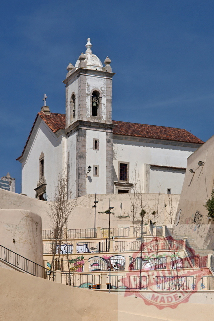 Historic church with bell tower overlooking urban stairs with graffiti | Whitewashed Portuguese church with a bell tower standing above graffiti-covered urban stairs - Realisiert mit Pictrs.com