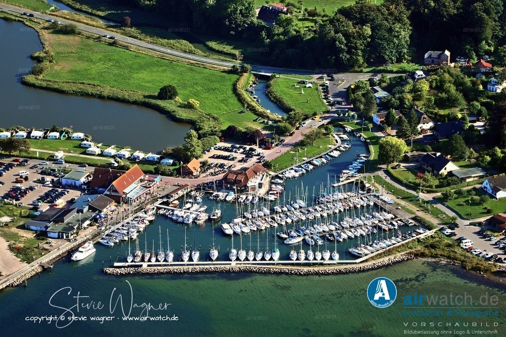 Luftbild Langballigau - Ein malerischer Hafenort an der Flensburger Förde | Langballigau, ein malerischer Hafenort an der Flensburger Förde, ist ein beliebter Anlaufpunkt für Segler und Wassersportler. Der Yachtclub Langballigau e.V., gegründet 1965, spielt eine zentrale Rolle im lokalen Segelleben und pflegt eine reiche Tradition an gemeinsamen Fahrten und Regatten. Mitglieder berichten auf der Vereinswebseite von spannenden Segelerlebnissen – etwa von Touren rund um Skagen oder an der dänischen Südsee, bei denen Crews auch bei schwierigen Wetterbedingungen durchhielten.
