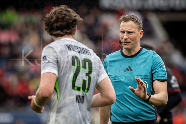 German Bundesliga, Bayer 04 Leverkusen vs. VfL Wolfsburg, 04.04.2026 | LEVERKUSEN, GERMANY - APRIL 4, 2026 :  referee Martin Petersen (Stuttgart) in discussions with Jonas Wind (VfL Wolfsburg, 23) during the German Bundesliga match on gameday 28 between Bayer 04 Leverkusen vs. VfL Wolfsburg at BayArena on April 4, 2026 in Leverkusen, Germany. DFL REGULATIONS PROHIBIT ANY USE OF PHOTOGRAPHS AS IMAGE SEQUENCES AND/OR QUASI-VIDEO.