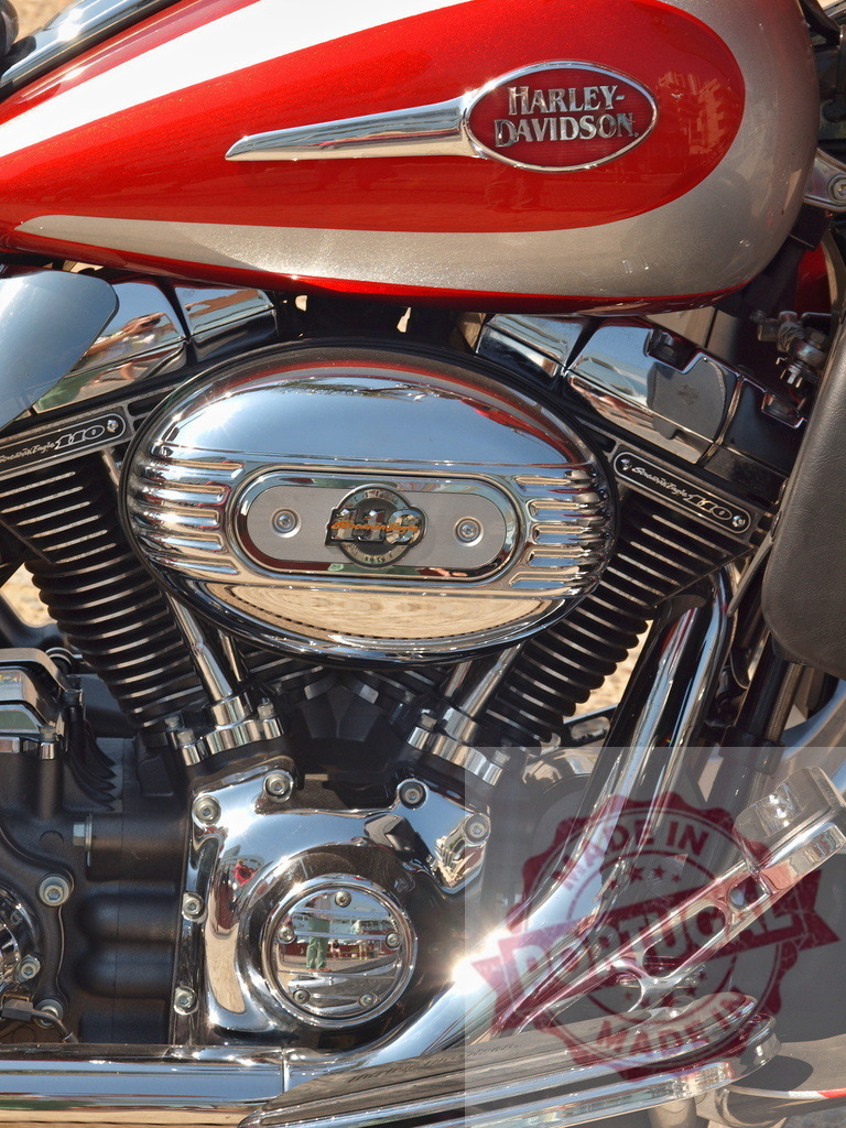 Harley-Davidson motorcycle engine chrome details on red tank | Harley-Davidson V-twin engine with chrome details and custom red and silver fuel tank - Realized with Pictrs.com