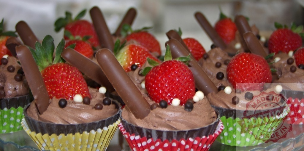 Chocolate cupcakes decorating with fresh strawberries | Rows of chocolate cupcakes with rich frosting, fresh strawberries, and chocolate sticks - Realisiert mit Pictrs.com