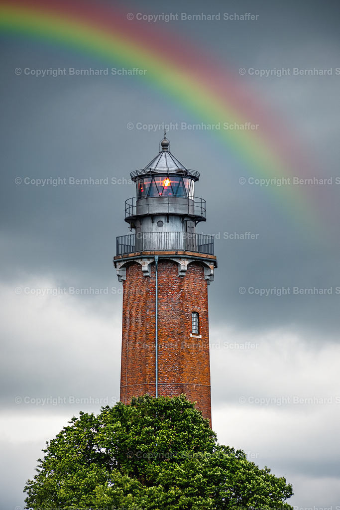 Leuchtturm Neuland | Der Leuchtturm Neuland an der Ostsee bei Regenwetter mit einem Regenbogen.  - Realisiert mit Pictrs.com