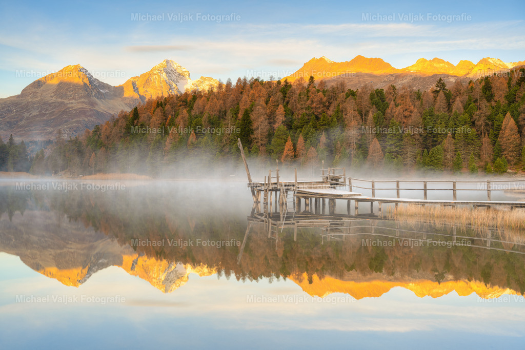 Sonnenaufgang am Stazersee im Engadin | Blick über den Stazersee bei St. Moritz im Oberengadin am Morgen. Leichte Nebelschwaden wabern über den See und die aufgehende Sonne taucht die Berggipfel in ein intensives warmes Licht.  - Realisiert mit Pictrs.com